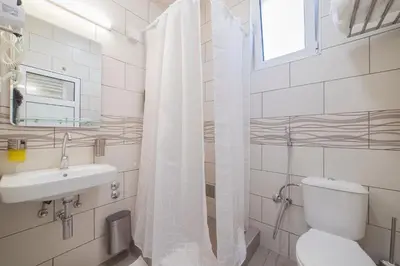 a white bathroom with a toilet and a sink at AS APARTMANI PIROT in Pirot