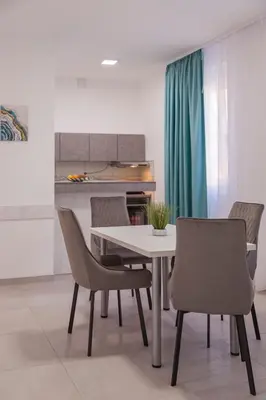 a dining room with a white table and chairs at AS APARTMANI PIROT in Pirot