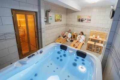 a bath tub in a bathroom with two people sitting in chairs at AS APARTMANI PIROT in Pirot