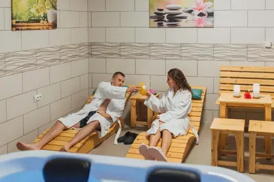 a man and a woman sitting on chairs in a room at AS APARTMANI PIROT in Pirot