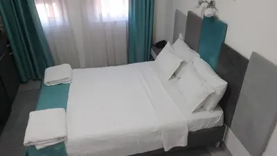a bedroom with a bed with white sheets and pillows at AS APARTMANI PIROT in Pirot