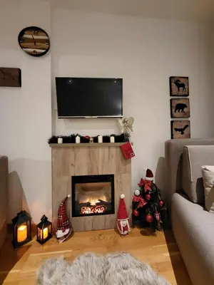 a living room with a fireplace with a tv above it at Apartman Ema, Kopaonik, Brzeće - BLIZU GONDOLE in Brzeće