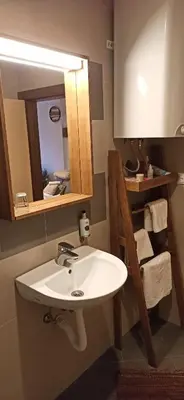a bathroom with a white sink and a mirror at Apartman Ema, Kopaonik, Brzeće - BLIZU GONDOLE in Brzeće