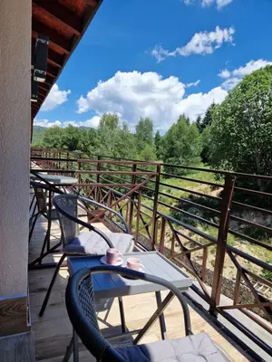 a patio with chairs and tables on a deck at Euphoria Milmari Resort Kopaonik in Kopaonik