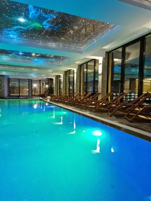 a hotel swimming pool with chairs and a star ceiling at Euphoria Milmari Resort Kopaonik in Kopaonik