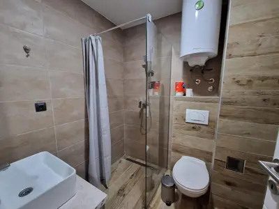 a bathroom with a shower and a toilet and a sink at Euphoria Milmari Resort Kopaonik in Kopaonik