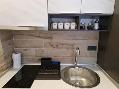 a kitchen counter with a sink and a stove at Euphoria Milmari Resort Kopaonik in Kopaonik