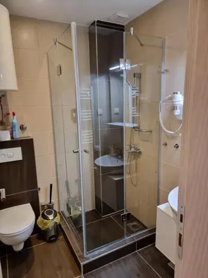 a bathroom with a glass shower with a toilet at BB Apartment 301, Župa Apartments in Kopaonik