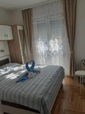 a room with a bed with a blue ribbon on it at Tanja Raj in Vrnjačka Banja