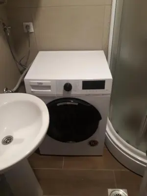 a washing machine in a bathroom next to a sink at Tanja Raj in Vrnjačka Banja