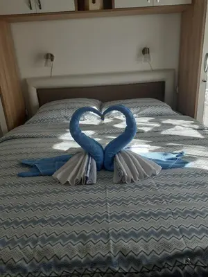 a bed with two blue towels in the shape of a heart at Tanja Raj in Vrnjačka Banja