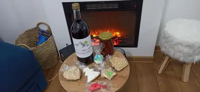 a bottle of wine sitting on a table in front of a fire at Apartman Nina, Kopaonik, Brzeće, Kod Gondole in Brzeće