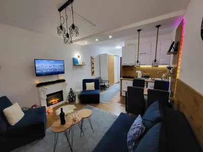 a living room with a blue couch and a fireplace at Apartman Nina, Kopaonik, Brzeće, Kod Gondole in Brzeće