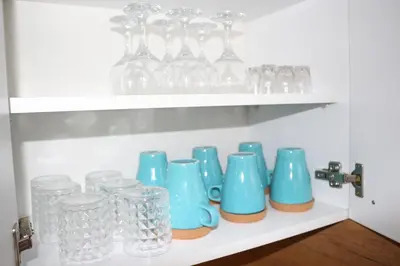 a shelf filled with glass vases and glasses at Apartman Nina, Kopaonik, Brzeće, Kod Gondole in Brzeće
