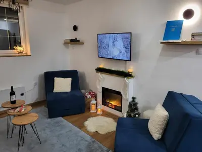 a living room with two blue chairs and a fireplace at Apartman Nina, Kopaonik, Brzeće, Kod Gondole in Brzeće