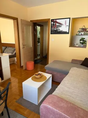 a hotel room with two beds and a table at Suncani apartman 36, Brzece in Brzeće