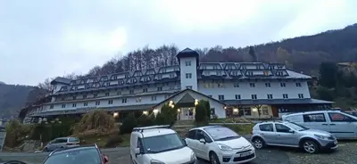 a large building with cars parked in a parking lot at BELE STAZE 18 - BRZEĆE KOPAONIK in Brzeće