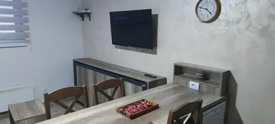 a dining room with a table and a clock on the wall at BELE STAZE 18 - BRZEĆE KOPAONIK in Brzeće