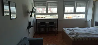 a room with a bed and windows in a room at City view - next to Delta Planet in Niš