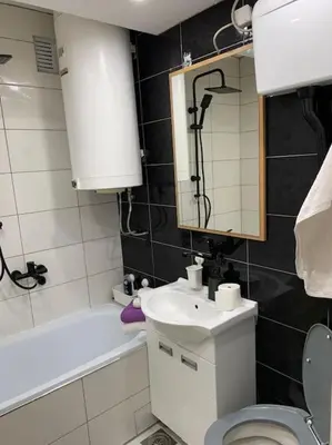 a bathroom with a sink and a toilet and a mirror at City view - next to Delta Planet in Niš