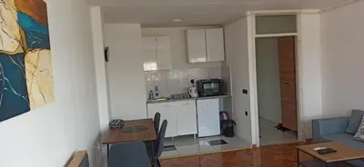 a kitchen and a living room with a table at City view - next to Delta Planet in Niš