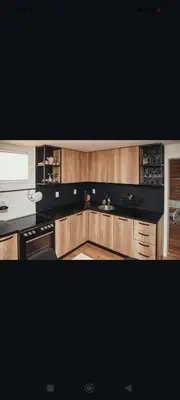 a kitchen with wooden cabinets and a black counter top at Kucica na brdu in Zaječar