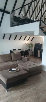 a living room with a brown couch and a table at Kucica na brdu in Zaječar