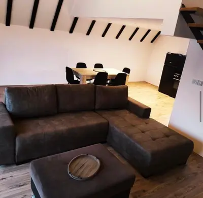 a living room with a brown couch and a table at Kucica na brdu in Zaječar