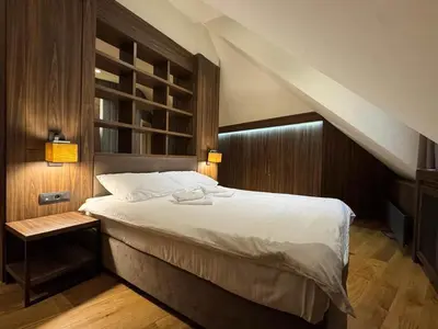 a bedroom with a large bed and a staircase at KULA ANDJELA KONACI - Kopaonik Ski Centar in Kopaonik