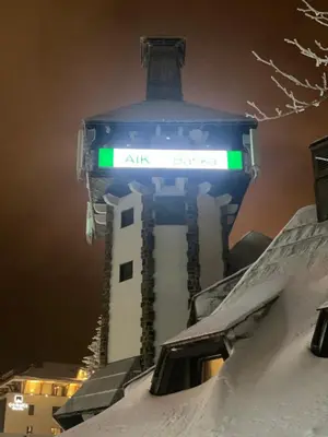 a tall building with a green sign on it at KULA ANDJELA KONACI - Kopaonik Ski Centar in Kopaonik