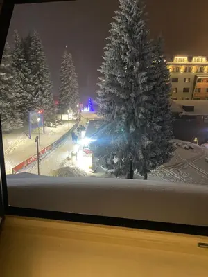 a window view of a snow covered park with a christmas tree at KULA ANDJELA KONACI - Kopaonik Ski Centar in Kopaonik
