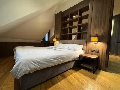 a bedroom with a large bed and a wooden floor at KULA ANDJELA KONACI - Kopaonik Ski Centar in Kopaonik