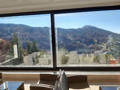 a large window with a view of a mountain at Apartman 1001 noc - Zoned 2 in Kopaonik