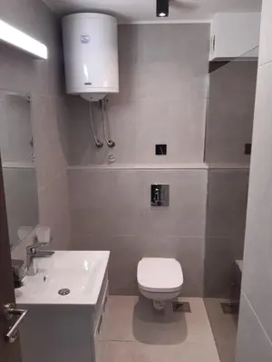 a bathroom with a white toilet and a sink at Apartman 1001 noc - Zoned 2 in Kopaonik