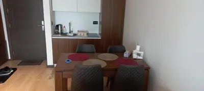 a dining room table with chairs and a kitchen at Apartman 1001 noc - Zoned 2 in Kopaonik