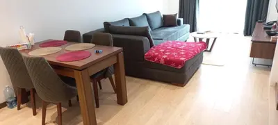 a living room with a table and a couch at Apartman 1001 noc - Zoned 2 in Kopaonik