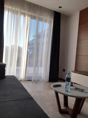 a bedroom with a table with a bottle of water on it at Apartman 1001 noc - Zoned 2 in Kopaonik