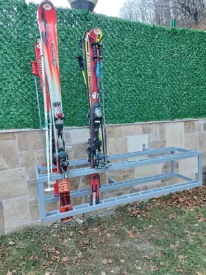 two skis and snowboards on a rack next to a wall at Vila MMBS in Brzeće