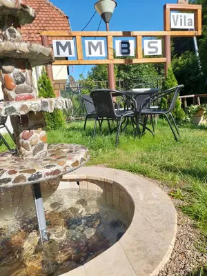 a fountain in a yard with a table and chairs at Vila MMBS in Brzeće