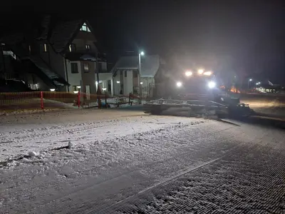 a train on tracks in the snow at night at Vila MMBS in Brzeće