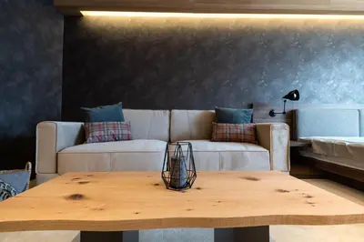 a living room with a couch and a wooden table at Woodside Residences & SPA in Kopaonik