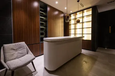 a kitchen with a chair and a white counter and a chair at Woodside Residences & SPA in Kopaonik
