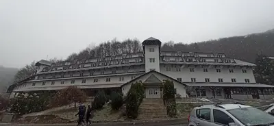 a large building on a hill with a car parked in front at Bele Staze 84, Ski tavanče, Brzeće in Brzeće