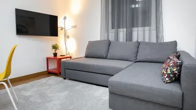 a living room with a gray couch and a tv at Apartment miTski Kop in Kopaonik