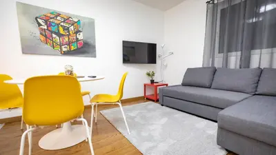 a living room with a couch and a table and yellow chairs at Apartment miTski Kop in Kopaonik