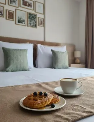 a plate with a waffle and a cup of coffee on a bed at Mountain Side Kopaonik in Kopaonik