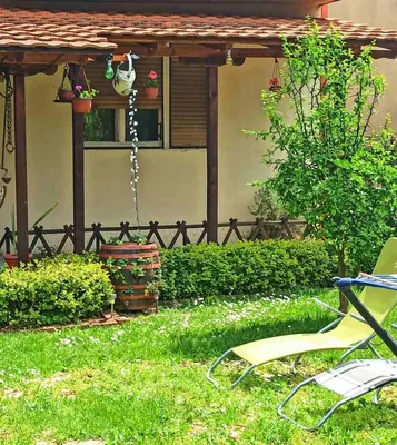 a yard with a pergola and a chair at Panonka apartman in Leskovac