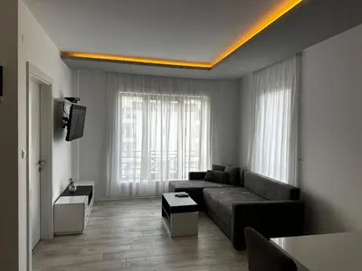 a living room with a couch and a tv at White Apartman Kopaonik in Kopaonik