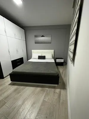 a bedroom with a bed and a wooden floor at White Apartman Kopaonik in Kopaonik