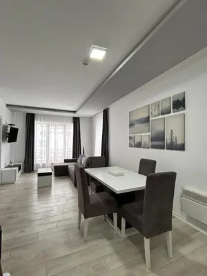 a living room with a dining room table and chairs at White Apartman Kopaonik in Kopaonik